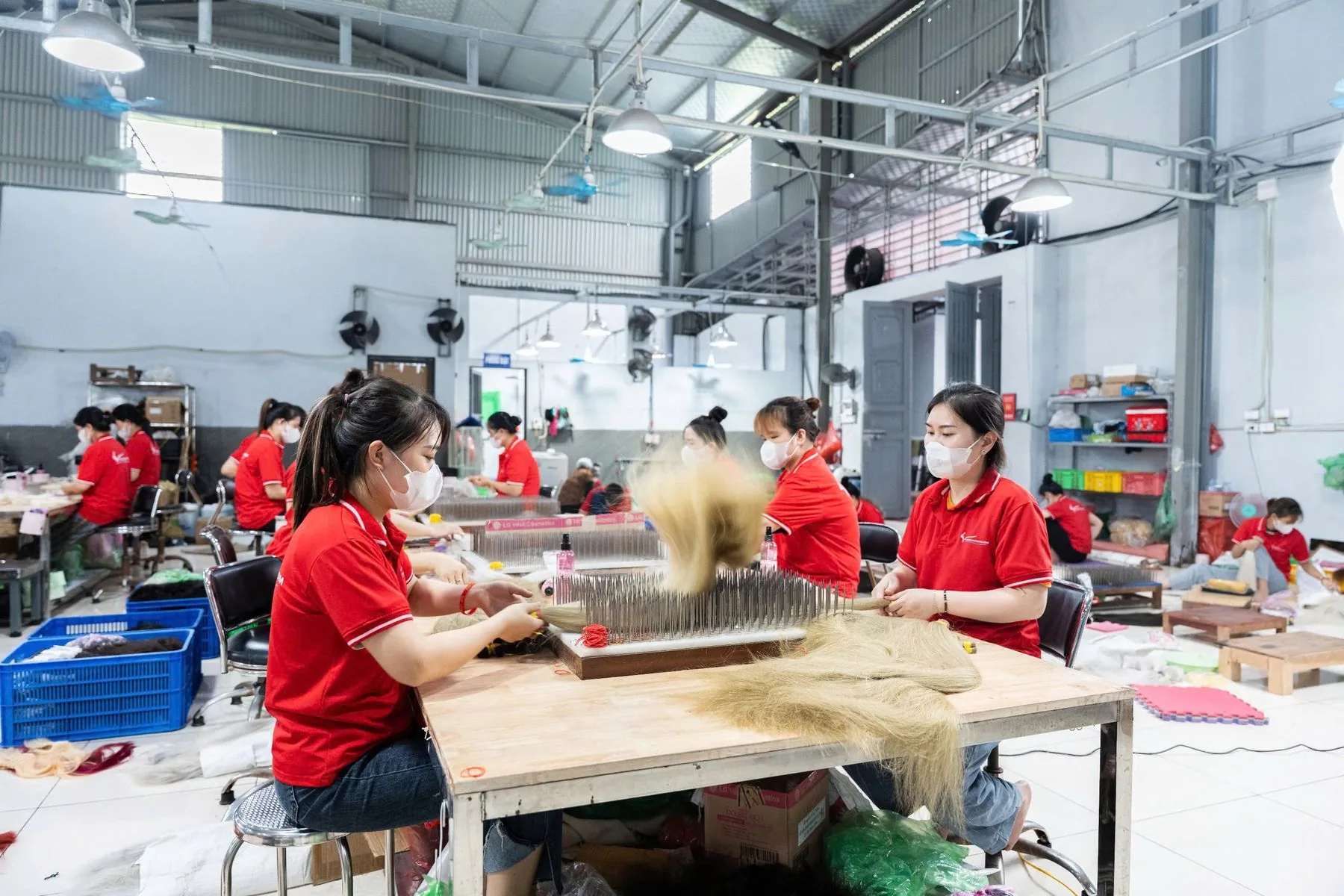 Artisans hand-tying hair wefts inside the Thanh An Hair factory in Bac Ninh